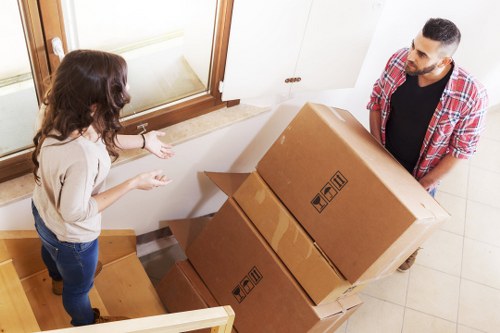 Local house removal team handling furniture and boxes in Acton